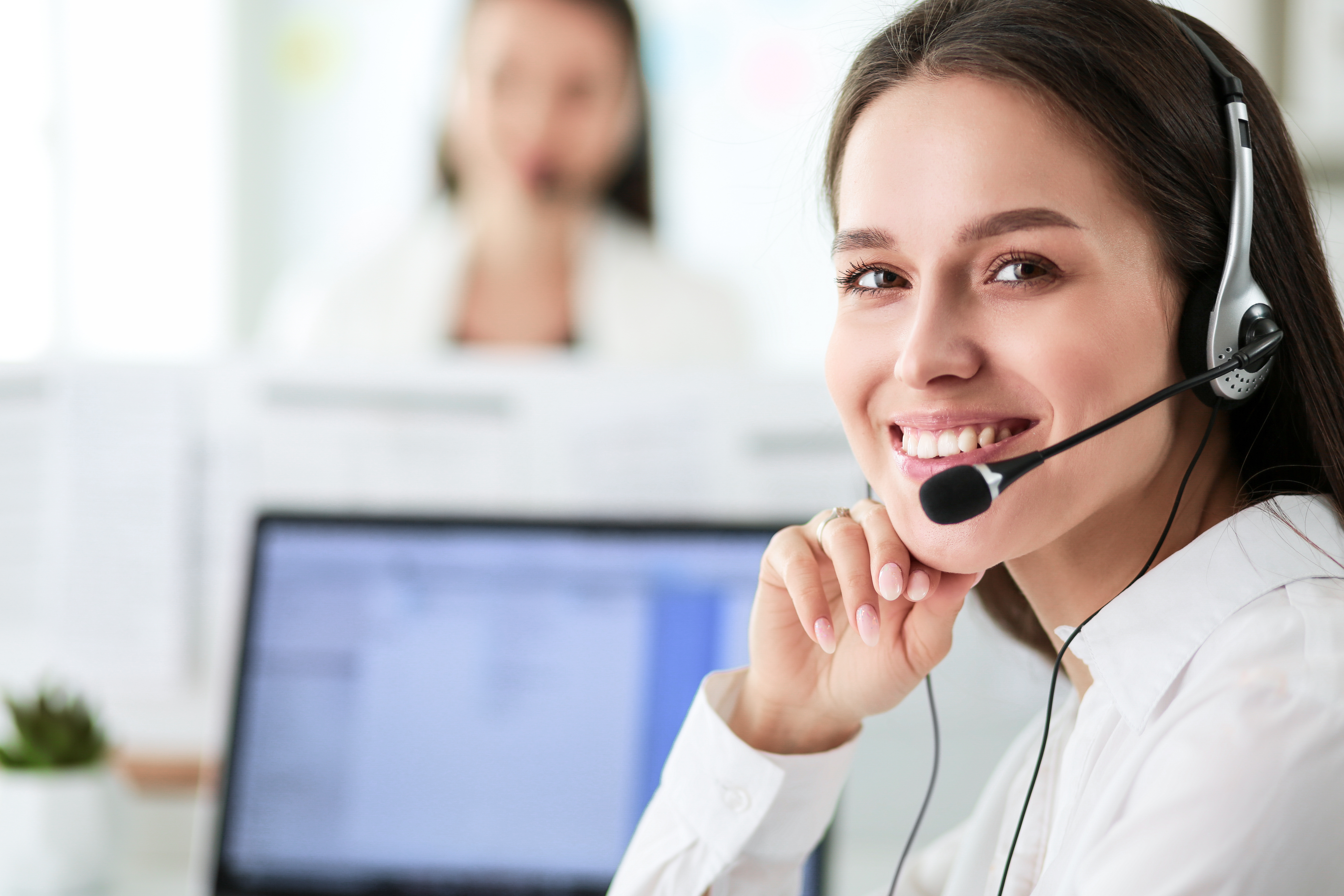  Smiling businesswoman or helpline operator with headset and computer at office 